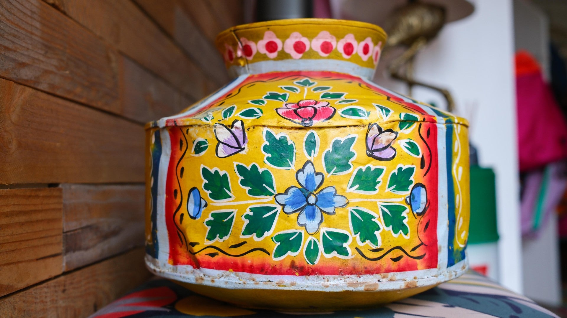 Colorful decorative vase with floral patterns on a wooden surface